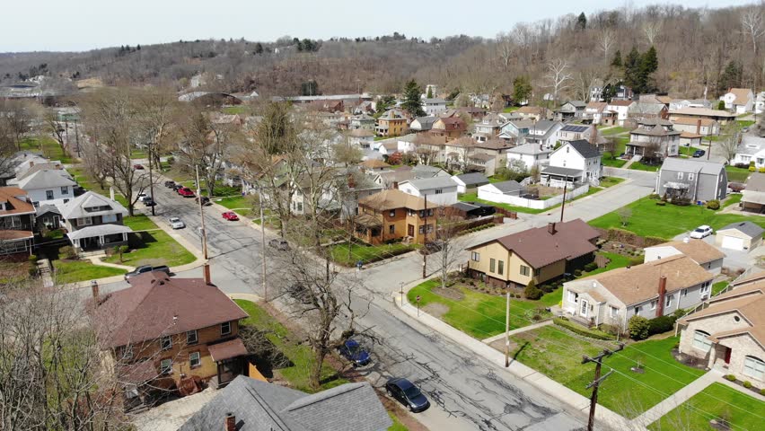 A slow daytime late winter aerial establishing shot of a typical residential neighborhood in a Western Pennsylvania small town. Pittsburgh suburbs.	