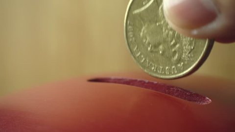 Coin being inserted into a vintage donation box, close-up, 4k