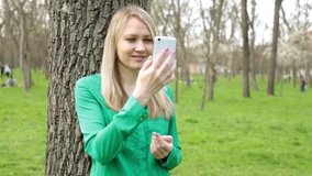 A young woman is talking on a video call using a smartphone.