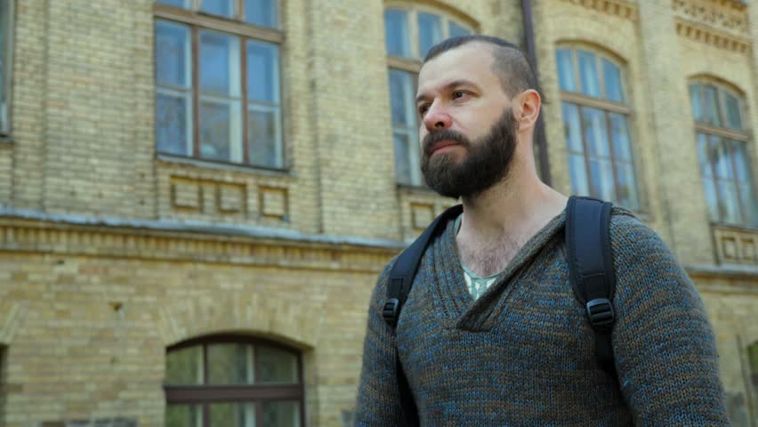 The man is walking along the old European street