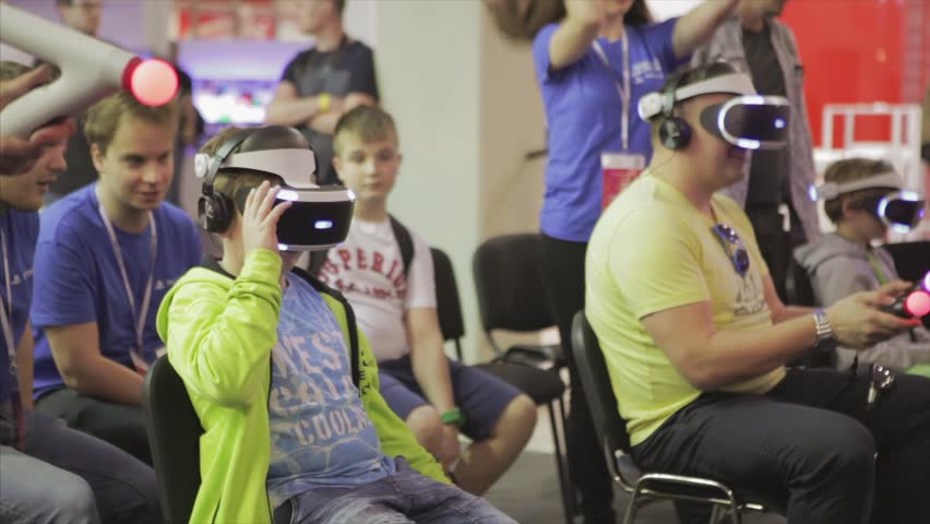 Warsaw-Poland, 15. April. 2018.Boy inside game simulator. Electronics Show - Trade Fair of Consumer Electronics. People are testing virtual reality games. | Shutterstock HD Video #1010132831