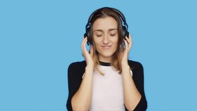 Slow motion of beautiful young female, woman, teenager or millennial hipster listen and enjoy favorite playlist song or music track, move with rhythm to beat, smile and chuckle in satisfaction
