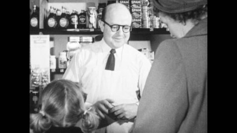 1940s: Customer buys items at store, leaves. Girl looks at lollipops on display, man nods at girl, hands her lollipop, pats her shoulder. Man holds social security card.