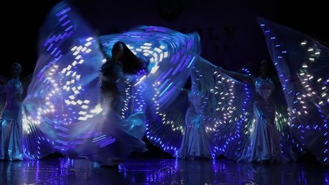 MOSCOW, RUSSIA - OCT 21, 2017: Dancers rotate and wave blue light dresses on stage of Luna Theatre during Gala Concert after 12th international festival of oriental dance ASSEMBLY 2017. Slow motion