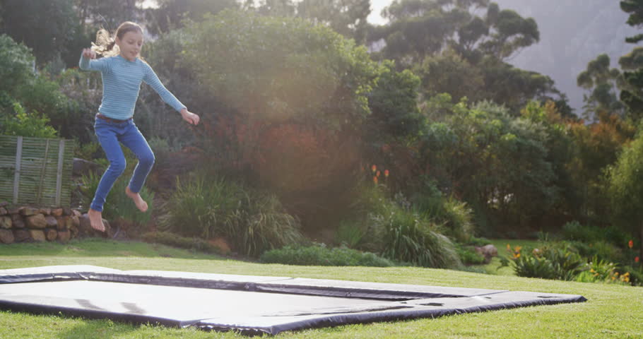 Little girl happily jumping on trampoline in garden 4K 4k