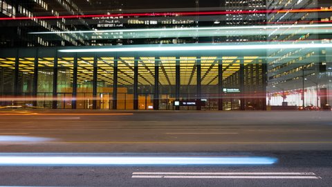 Cars travelling down Bay street in downtown Toronto, Ontario Canada. Long exposure light trails show a fast paced city at night. Futuristic and modern architecture in the background.