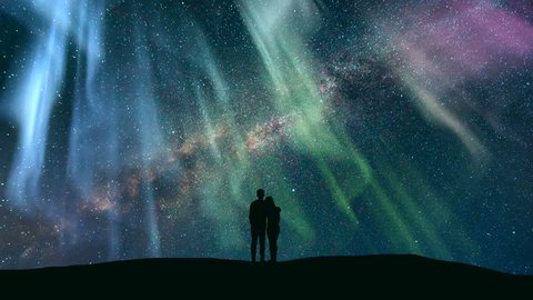 The couple standing against the northern light with a northern light. time lapse