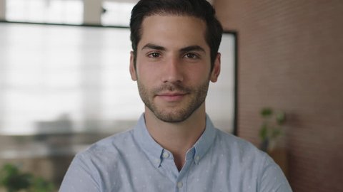 close up portrait of young attractive middle eastern businessman looking at camera smiling confident in office workspace background real people series