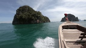 4K Wooden long tail boat on the waves with island at Thailand