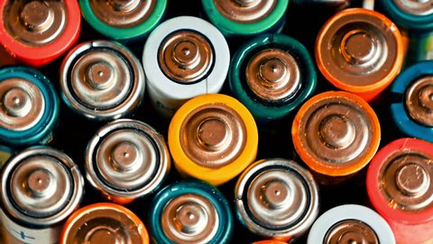 Used batteries from different manufacturers, waste, collection and recycling, high danger for the environment. Batteries background
