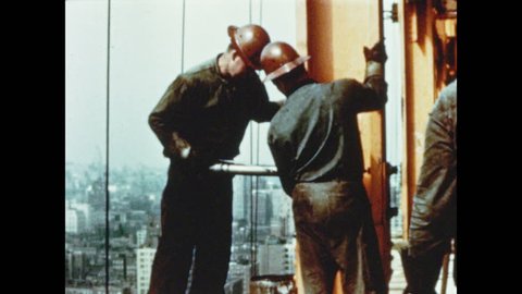1950s: Men attach beams to column with air hammer. Illustrated picture of skyscraper construction progress. Skyscraper construction frame stands near river in city.