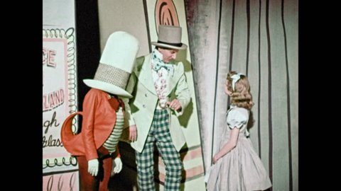 1950s: Little girl shakes hands with Mad Hatter and Jabberwocky. Mad Hater shoos the little girl away. The little girl looks confused but approaches the animated letters.