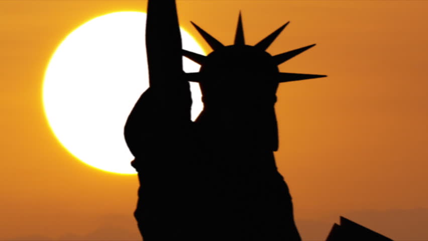 A stunning view of the Statue of Liberty in New York City against a big sun on a golden sky.

Relevant to coronavirus, covid-19, sars-cov-2 corona virus viral outbreak. Royalty-Free Stock Footage #1010204945