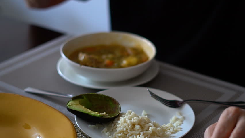 Close-Up of Senior Man Eating Lunch at Home - Chicken soup, rice and avocado