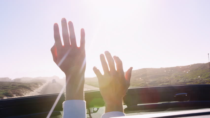 Young couple driving reaching hands out through car sunroof Royalty-Free Stock Footage #1010206400
