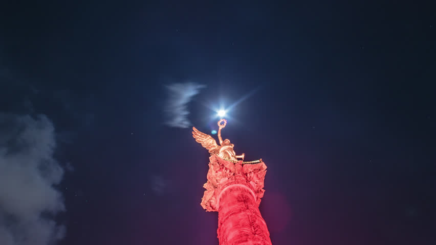 Timelapse of The Independence column also called Angel de la independencia, illuminated in red with full moon background