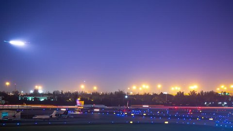 Vibrant Commercial Aviation Airport Airfield Action Timelapse at Night with Light Streaks from Jet Airliners Landing and Taking off in a Colorful Sky