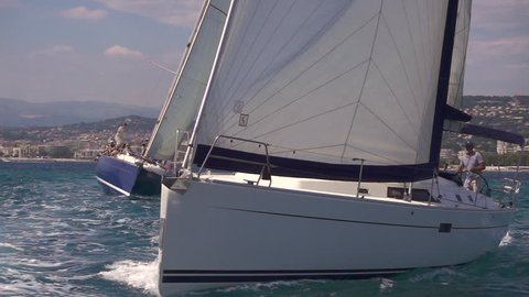 Two sailing boats cut through the water on the sea in super slow motion. Off the coast of Cannes.