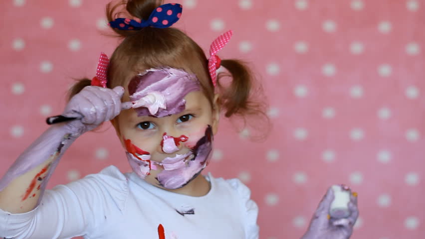 Body art. A funny child paints his face and hands with paint. dirty artist. Little girl draws makeup Royalty-Free Stock Footage #1010214647