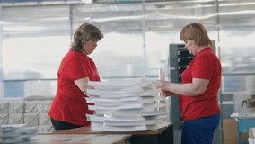 Female workers sorting a paper stacks in the typography - Powered by Shutterstock - Get 15% off with code: PIKWIZARD15