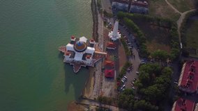 Top down aerial view footage - View of a White Floating Mosque, The Melaka Straits Mosque, located on the man-made Malacca Island near Melaka City, Melaka, Malaysia. Clip record by drone