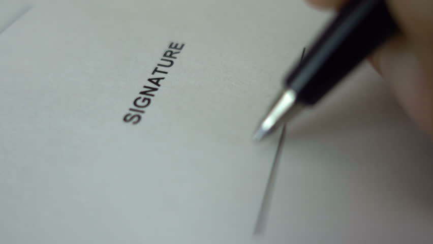 Businessman signing business contract agreement, close up of male hand with pen writing signature