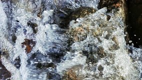 Vertical video. Water falls from the rock. Recorded with high shutter speeds. Valley Issyk-Ata, Kyrgyzstan