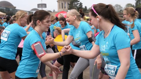 WROCLAW, POLAND - APR 15, 2018: Festive sport female crowd playfully warming up befor charity marathon run