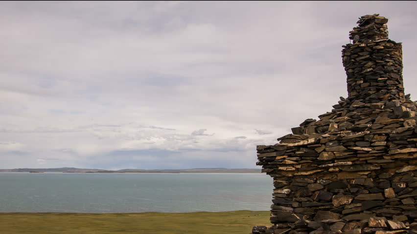 Scenic tibetan highland landscape with buddhist stupa, clouds and mountains in skyline. Source of Yellow River (Huang He). Tibetan Plateau in Qinghai Province, Amdo region, China. 4K UHD timelapse.
