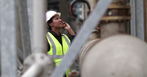 Female industrial worker using radio on site