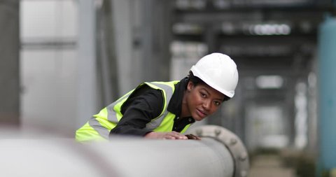 Female industrial worker checking pipeline