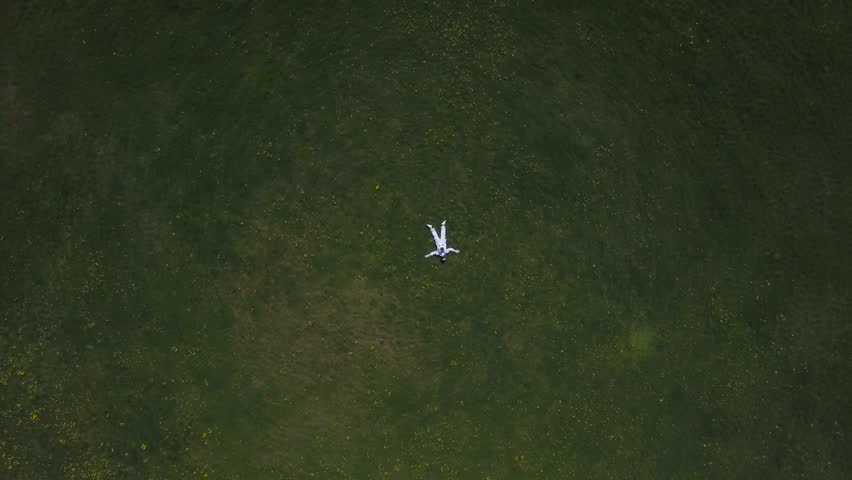 Astronaut lying on the grass looking at the sky