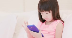 cute girl play phone and sit on the bed