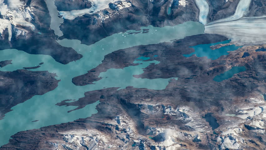 Flying over the earth on the ISS. Flying over the snow-capped mountains, aerial view from space.