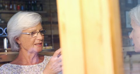 Active senior woman interacting in cafe 4k วิดีโอสต็อก
