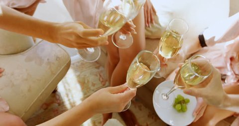 Bridesmaids in nightdress toasting a glass of champagne at home 4K 4k