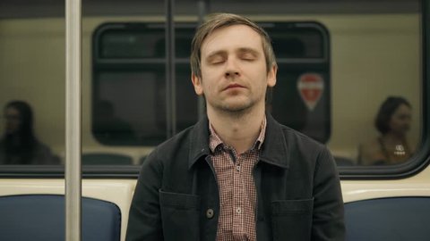 man sleeping in a underground Metro subway train. Tired worker student sleep after work, hard day, illness, fatigue, tiredness,