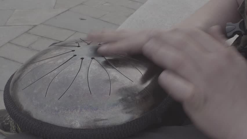 Male hands playing on hapi drum Close up