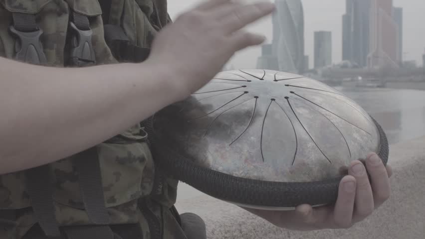 Hands play on hapi drum on waterfront