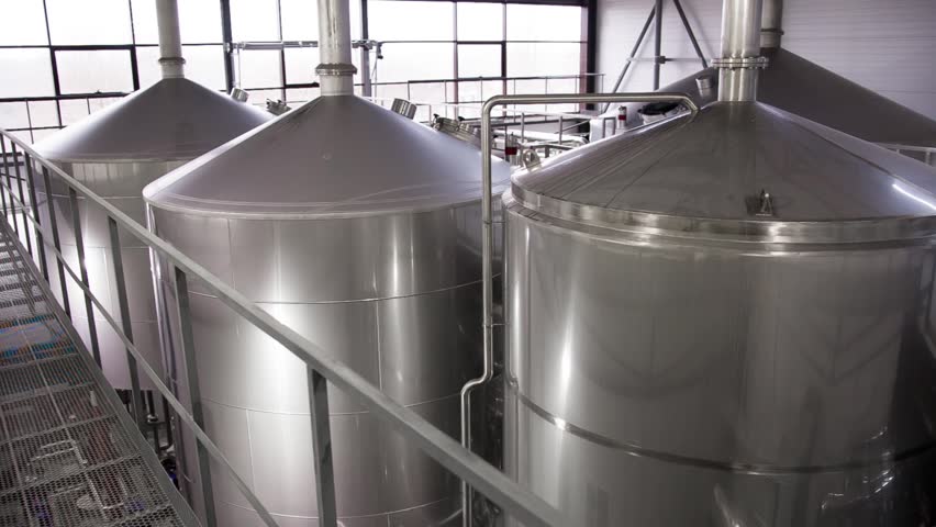 Row of tanks in brewery.  Fermentation in a brewery tanks with beer for brewing. Modern beer factory. Big steel tanks for storage. | Shutterstock HD Video #1010301815