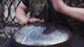 Hands playing musical hapi Drum