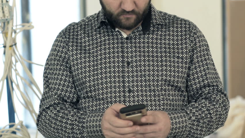 Young, happy man talking on cellphone at new home
