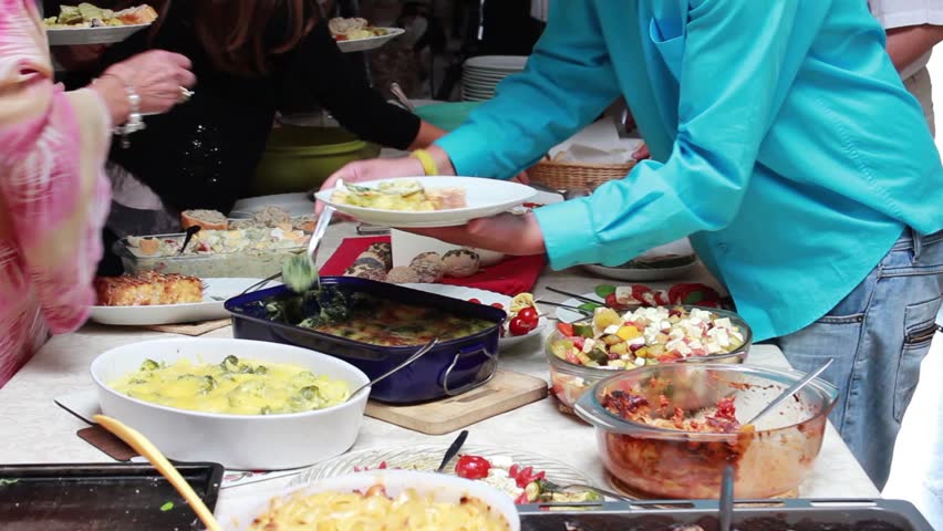each helping one-self from the rich variety of food at the free buffet - potluck time Royalty-Free Stock Footage #1010308418