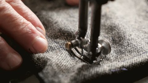Sewing clothes on an old sewing machine. Close-up of needle and thread. Slow-motion filming