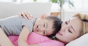 son lying on mother body at home