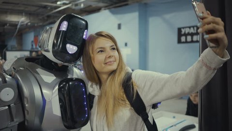 Samara, Russia - April 26, 2018: robot city. robot city - interactive scientific exhibition of robots. Modern hi-tech robotic technologies. Young girl makes a photo with a robot