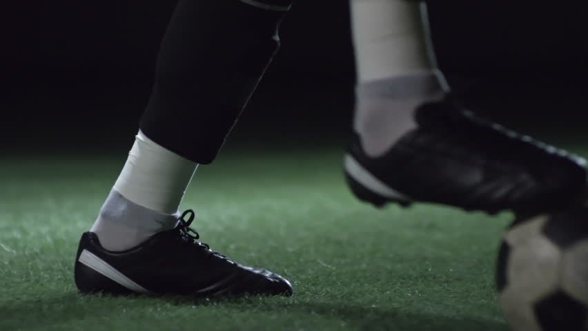 Closeup of feet of professional male soccer player training with ball on stadium field with artificial turf Royalty-Free Stock Footage #1010318069