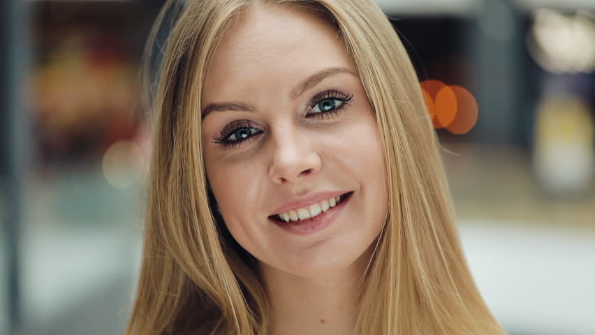 Attractive young woman look ar camera smiling feel happy in mall close up shopaholic fashion clothing girl shopping money lifestyle store portrait weekend shop slow motion