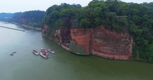 Aerial drone view of the impressive giant Buddha statue in Leshan, tourist view the site on boat, China, 4k
