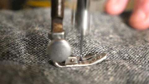 The process of sewing clothes on a sewing machine. Close-up of needle for sewing. Slow Motion